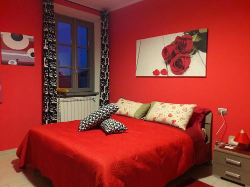 a red bedroom with a red bed with a redspread at Affittacamere Erbagatta in Erba