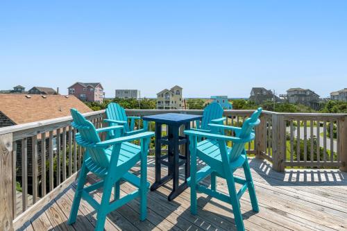 a patio with four chairs and a table on a deck at The Tip Sea Mermaid in Salvo