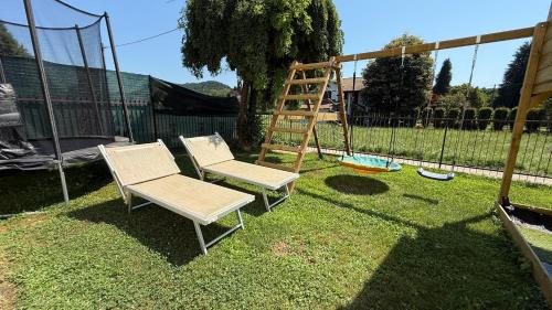 two chairs and a swing set in a yard at Guest House - MXP, Lakes, Leonardo, 2 bedrooms in Sesto Calende