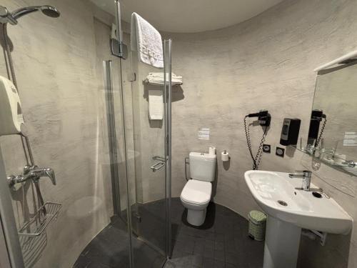 a bathroom with a shower and a toilet and a sink at Hotel Punta Monpas in Donostia-San Sebastián