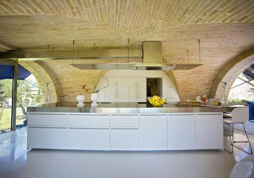 a kitchen with white cabinets and a wooden ceiling at Villa Chloe in Potenza Picena