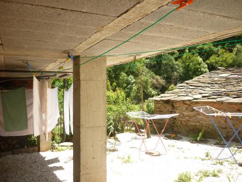 a patio with a table and chairs and a stone wall at Pensión Santa Rosa in Samos