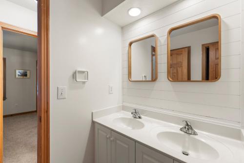 a bathroom with a sink and two mirrors at The Tipsea Turtle in Corolla