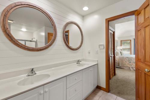 a bathroom with two sinks and two mirrors at The Tipsea Turtle in Corolla