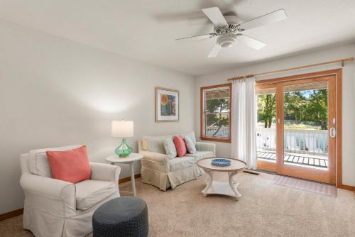 a living room with two chairs and a ceiling fan at The Tipsea Turtle in Corolla