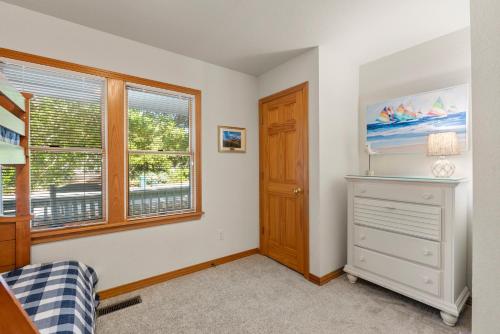 a bedroom with a dresser and a window at The Tipsea Turtle in Corolla