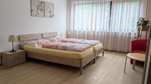 a bedroom with a bed and a chair and a window at Ferienwohnung Eppler in Albstadt