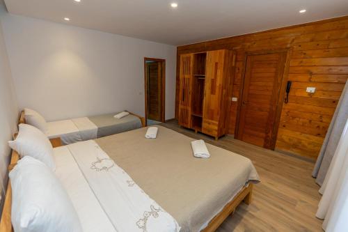 a bedroom with two beds and a wooden door at Bujtina Berishta Theth in Theth