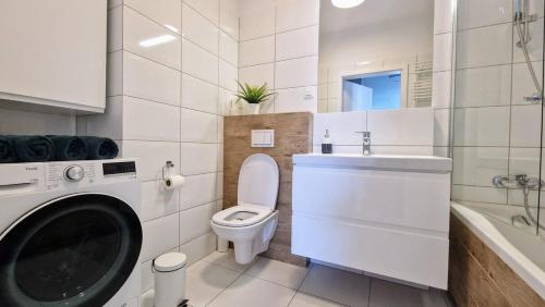 a bathroom with a washing machine and a toilet at Luxury in City -14- Stylish Free Parking in Łódź