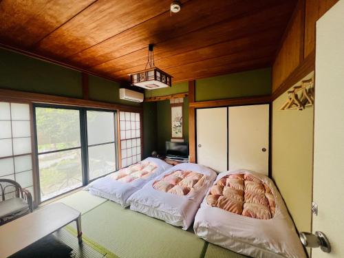 a room with three beds in a room with windows at Stay Nikko Guesthouse in Nikko