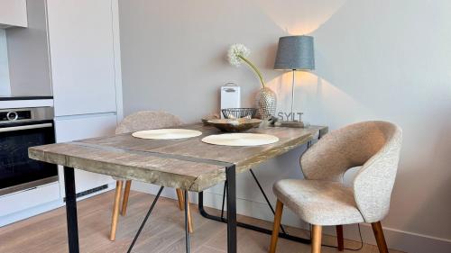 una cucina con un tavolo di legno e due sedie di CityLounge a Westerland