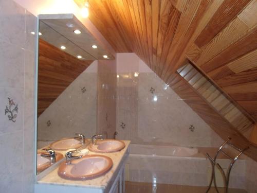 a bathroom with two sinks and a bath tub at Villa spacieuse à Concarneau avec piscine privée in Concarneau