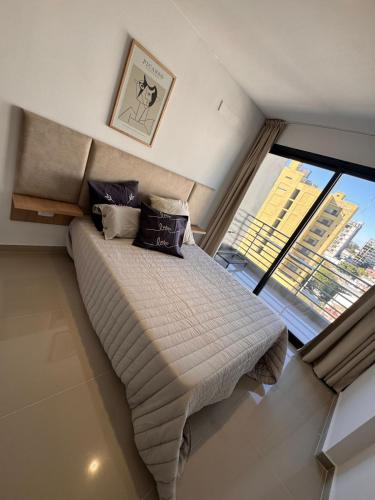 a bed in a room with a large window at Suit Chalet Santiago in Santiago del Estero