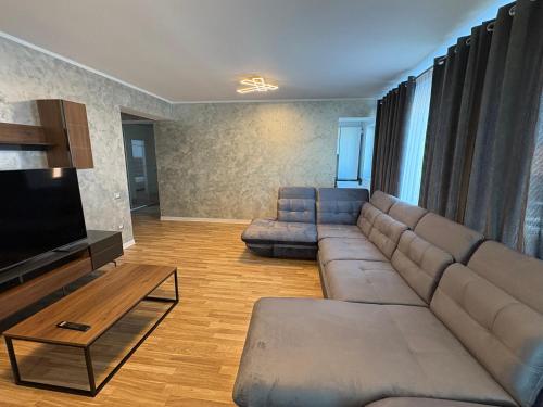 a living room with a couch and a flat screen tv at Apartament Luxury nino in Focşani