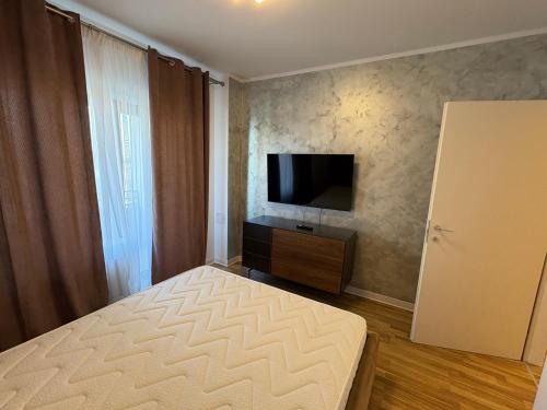 a bedroom with a bed and a flat screen tv at Apartament Luxury nino in Focşani