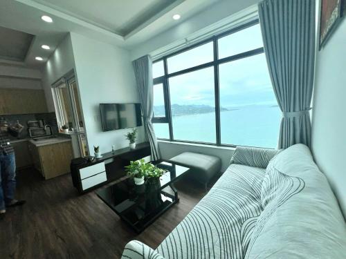 a living room with a couch and a large window at Stay in Nha Trang Apartment in Nha Trang