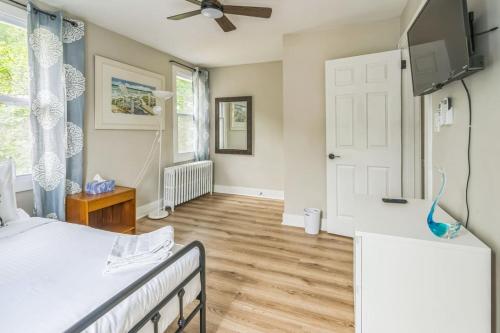 a bedroom with a bed and a flat screen tv at Where Classic Charm Meets Modern Serenity in Pittsburgh