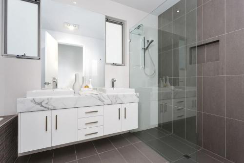 ein weißes Bad mit 2 Waschbecken und einer Dusche in der Unterkunft JBS Retreat Rate variable see rates below in Swanport