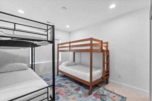 a bedroom with two bunk beds and a rug at Cherry Hill stay and play near lagoon in Kaysville