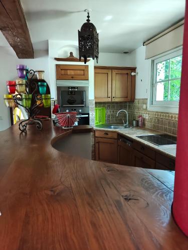 a kitchen with wooden cabinets and a wooden counter top at VILLA privée MYRIAMI BEACH in Lattes