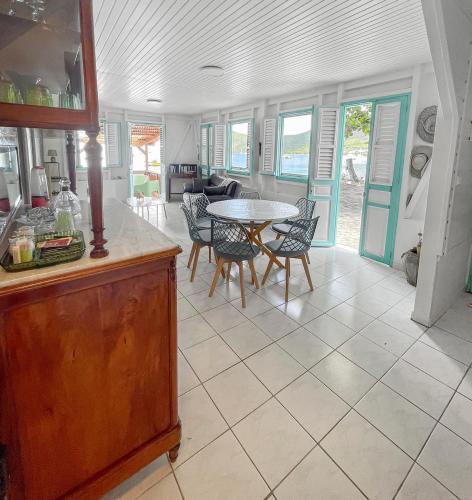 a kitchen and dining room with a table and chairs at Évasion créole à Grande Anse in Les Anses-dʼArlets