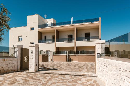 a large white building with a brick courtyard at Eleia Mirea in Monopoli