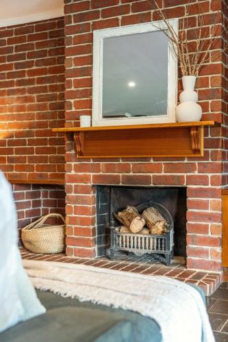 a brick fireplace with a television on top of it at Secluded Stylish and Spacious The LostPlot 