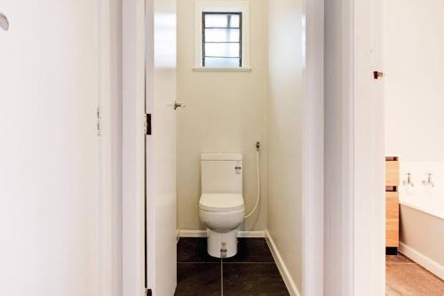 a bathroom with a toilet and a sink at Countryside 4BR Family Home near Airport in Auckland