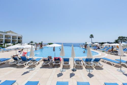 un groupe de chaises et de parasols à côté d'une piscine dans l'établissement Cannes - Vue mer avec Piscine, Clim & Parking - 10 min de la Croisette - FRAGONARD, à Cannes