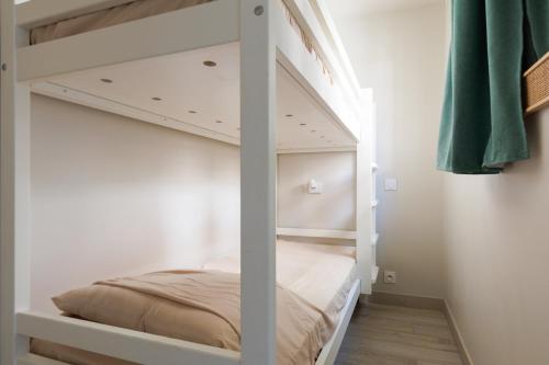 Ce lit superposé blanc se trouve dans un dortoir. dans l'établissement Cannes - Vue mer avec Piscine, Clim & Parking - 10 min de la Croisette - FRAGONARD, à Cannes