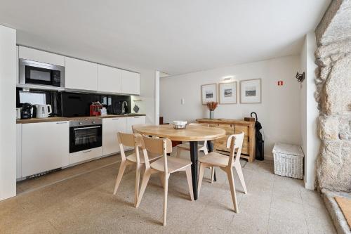 a kitchen and dining room with a wooden table and chairs at GuestReady - Your Porto Hideaway in Porto