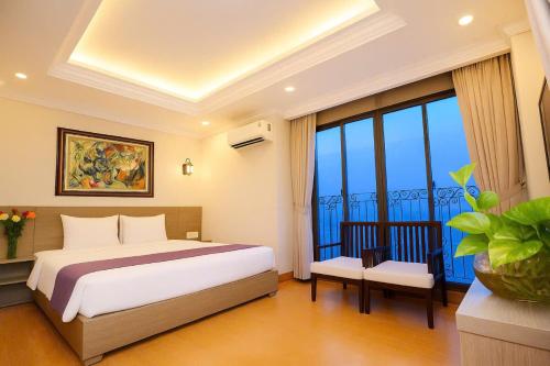 a bedroom with a bed and a large window at Yen Indochine in Nha Trang