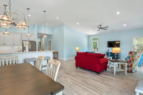 a living room and dining room with a red couch at Tranquility Cove in Nags Head