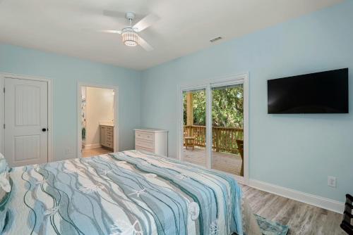 a bedroom with a bed and a flat screen tv at Tranquility Cove in Nags Head
