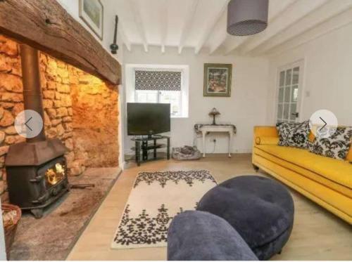 a living room with a couch and a fireplace at Broadwindsor Cottage in Broadwindsor