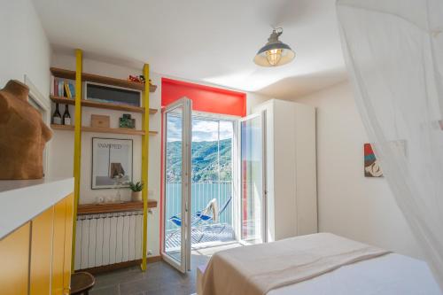 a bedroom with a bed and a door to a balcony at Casa Corbu by Rent All Como in Blevio