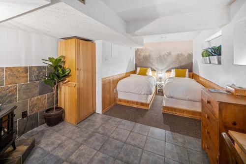 a bedroom with two beds in a room at Mountain View Retreat in the heart of Banff - Massive House Sleeps 23 in Banff