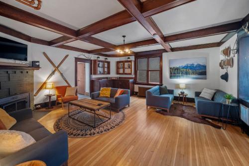 a living room with blue chairs and a fireplace at Mountain View Retreat in the heart of Banff - Massive House Sleeps 23 in Banff