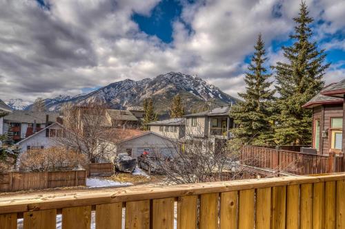 a house with a fence and a mountain in the background at Mountain View Retreat in the heart of Banff - Massive House Sleeps 23 in Banff
