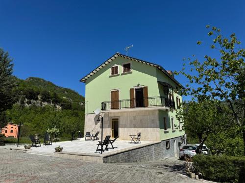 a green building with a balcony on top of it at CASA DI BETTA Appartamento 3 Ascoli, Norcia, Monti Sibillini in Piana di Forcella