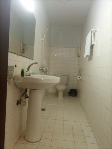 a bathroom with a sink and a toilet at Hilltop Totel in Karachi