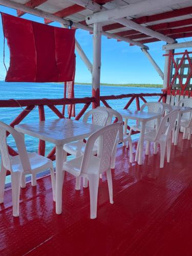 a row of tables and white chairs on a boat at Hostel bunker Peruano in Playa Blanca