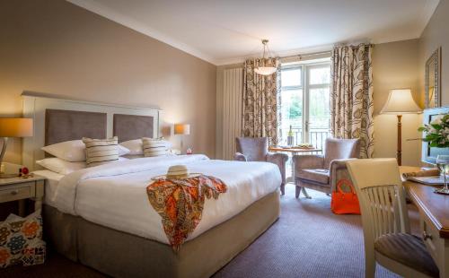 キルケニーにあるKilkenny River Court Hotelの大きなベッドとデスクが備わるホテルルームです。