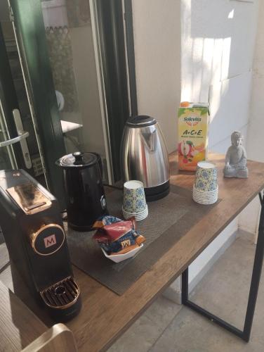 a table with a coffee maker and cups on it at Fiore di Loto Rooms in Carini