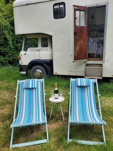 two chairs and a table in front of an rv at Monroe Horsebox Glamping in Porthleven
