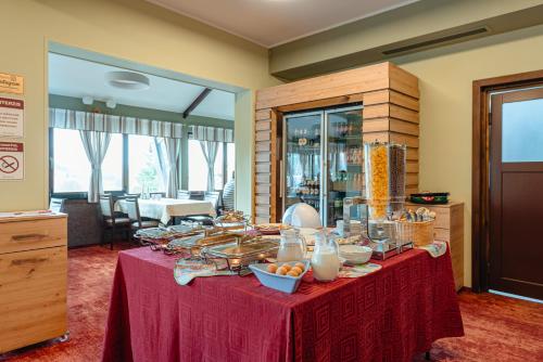 a table with a red table cloth with food on it at Pensiunea La Bella Vista in Poiana Negrii