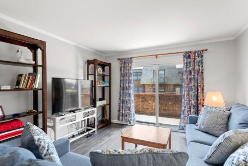 a living room with a blue couch and a tv at Villas M1 in Nags Head