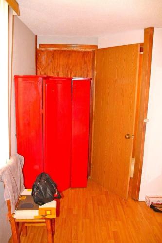 a room with red cabinets and a table with a bag at BUAP CU Casa Nopal in Chapulco