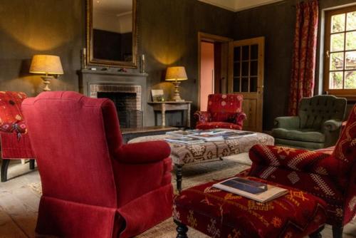 WijerにあるB&B Kasteelhoeve de Kerckhemのリビングルーム(赤い椅子、暖炉付)
