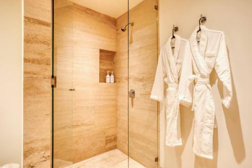 a glass shower stall with a robe on a rack at Group Apt 13 16, no view, 3BR, 12 pax in Cabo San Lucas